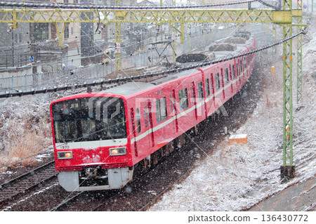 1500系列車沿著京急線飛馳而過，整個地區都被白雪覆蓋。 136430772