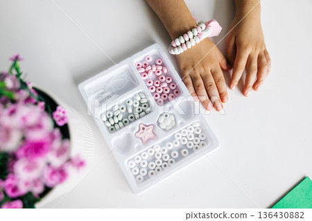 Crafting colorful jewelry with beads and flowers in a bright workspace Crafting colorful jewelry with beads and flowers in a bright workspace 136430882