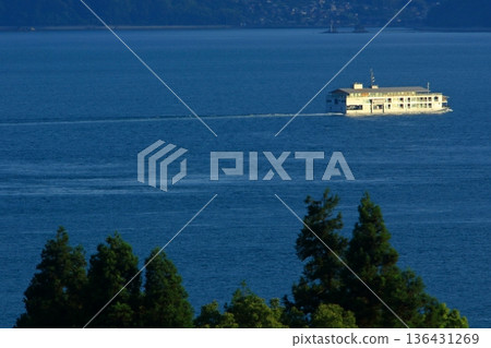 A cruise ship slowly sailing through the Seto Inland Sea bathed in the setting sun A cruise ship slowly sailing through the Seto Inland Sea bathed in the setting sun 136431269