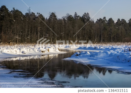 A snow-covered sunny landscape with winding river and trees 136431511