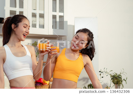 Two sporty women drinking green smoothie and eating fresh vegetables. Two sporty women drinking green smoothie and eating fresh vegetables. 136432306