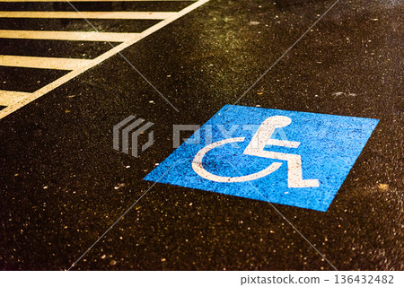 Blue handicap parking sign painted on wet asphalt ground Blue handicap parking sign painted on wet asphalt ground 136432482