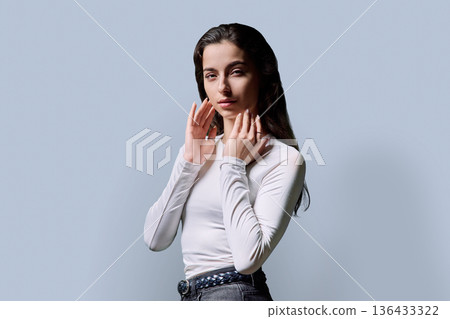 Portrait of beautiful fashionable young woman 18, 19 years old on gray background 136433322