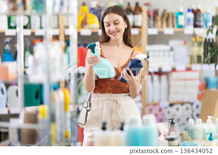 Girl choose kitchen cleaner spray in household shop Girl choose kitchen cleaner spray in household shop 136434052