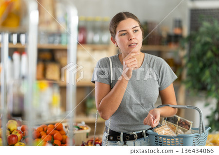Woman in gray t-shirt in supermarket Woman in gray t-shirt in supermarket 136434066