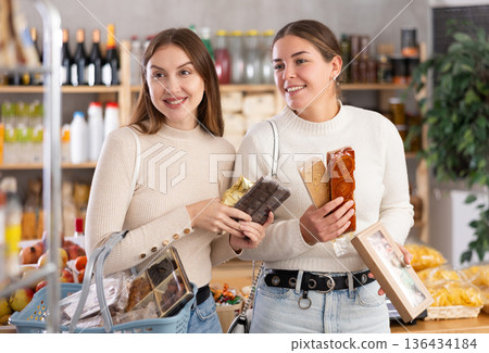 Women choose Spanish sweets in the store 136434184