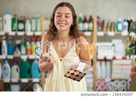 Positive young woman shopping for cosmetics in store 136434207