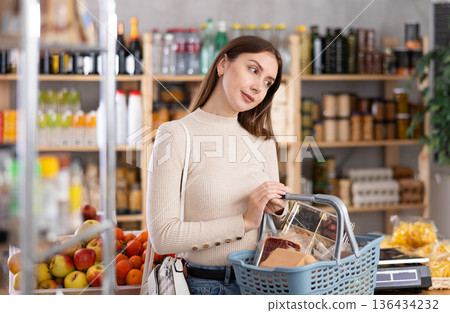 Young woman choosing food in grocery store 136434232