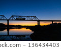 A local train running over a railway bridge at dawn 136434403