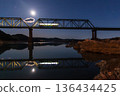 A local train running on a railway bridge under the moonlight 136434425