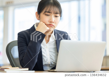 Worried woman looking at computer screen 136434632