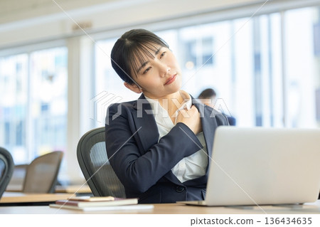 A businesswoman who feels stiff shoulders while working A businesswoman who feels stiff shoulders while working 136434635