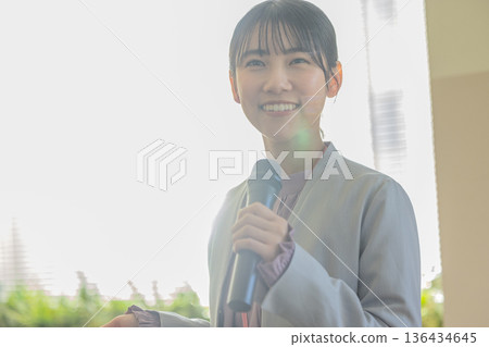 Young woman speaking with a microphone Young woman speaking with a microphone 136434645