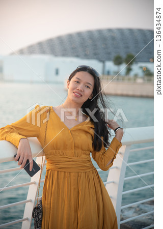 Fashionable Young Asian Woman in Yellow Outfit Outside Louvre Abu Dhabi United Arab Emirates 136434874