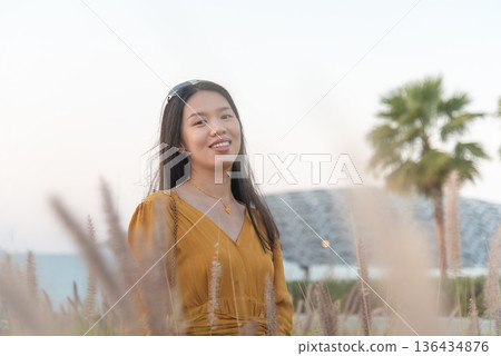 Fashionable Young Asian Woman in Yellow Outfit Outside Louvre Abu Dhabi United Arab Emirates 136434876