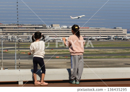 Two children looking at the plane from the observation deck of the airport Two children looking at the plane from the observation deck of the airport 136435295