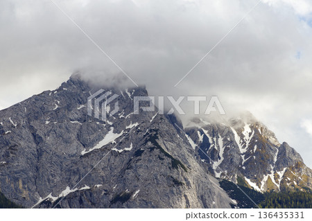 Rocky mountain ridge of Zugspitze under cloudy sky. Rugged alpine landscape texture. Rocky mountain ridge of Zugspitze under cloudy sky. Rugged alpine landscape texture. 136435331