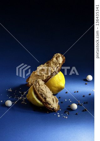 Close up of lemon and crispbread snack with spices on blue background with dramatic shadows. Close up of lemon and crispbread snack with spices on blue background with dramatic shadows. 136435341