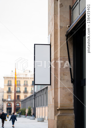 Blank outdoor storefront sign on an urban Barcelona street, blank white mockup for business branding, advertising and promotional copy space on a commercial retail facade 136435401