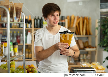 Man choosing pasta at grocery store 136435808