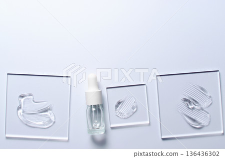 A sample of a transparent cosmetic skin care product on glass. Blue background 136436302