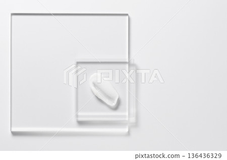 White cosmetic skin care product on glass. White background. Copy space White cosmetic skin care product on glass. White background. Copy space 136436329