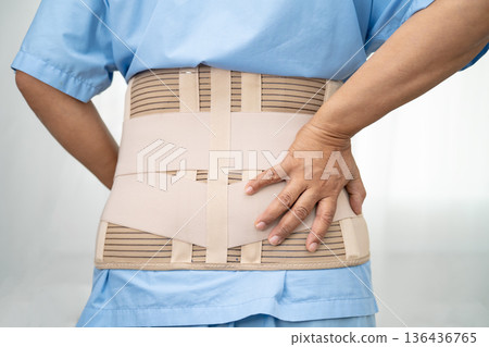 Asian lady patient wearing back pain support belt for orthopedic lumbar with walker. Asian lady patient wearing back pain support belt for orthopedic lumbar with walker. 136436765