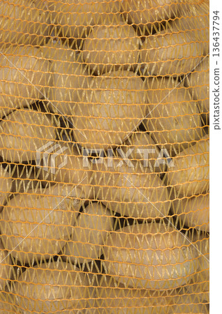 Raw Potatoes in Orange Plastic Mesh Bag 136437794