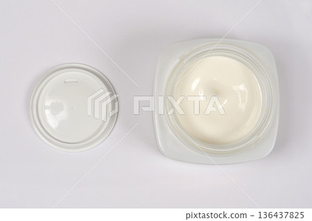 Open white cosmetic jar with cream top view 136437825