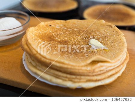 cooking traditional pancakes from wheat flour in the kitchen 136437923