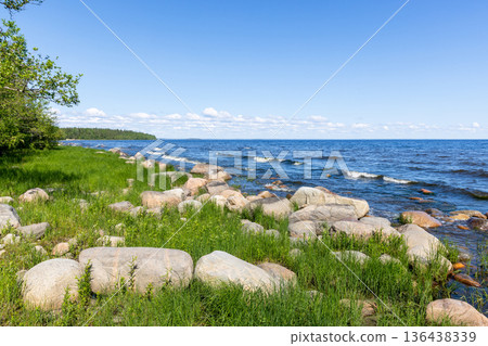 Tranquil Ladoga lakeside scene with green grass and rocks Tranquil Ladoga lakeside scene with green grass and rocks 136438339