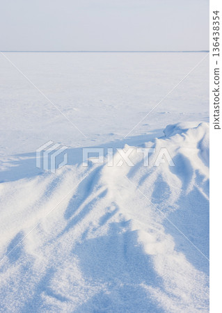 A vast snow covered frozen sea stretches to the horizon 136438354