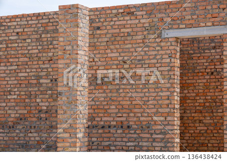 Bricklayers work diligently to create a strong wall structure, highlighting precision and hard work in a construction site bathed in sunlight Bricklayers work diligently to create a strong wall structure, highlighting precision and hard work in a construction site bathed in sunlight 136438424