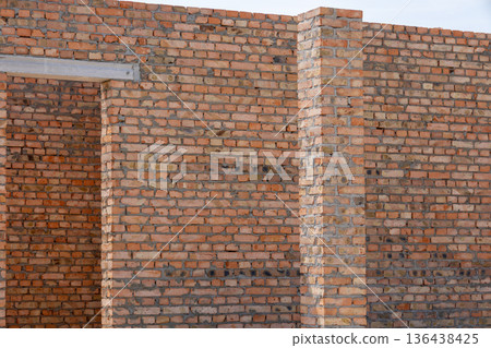 Sturdy bricks align perfectly in the sun, displaying skillful work at a construction site. The structure takes shape steadily Sturdy bricks align perfectly in the sun, displaying skillful work at a construction site. The structure takes shape steadily 136438425