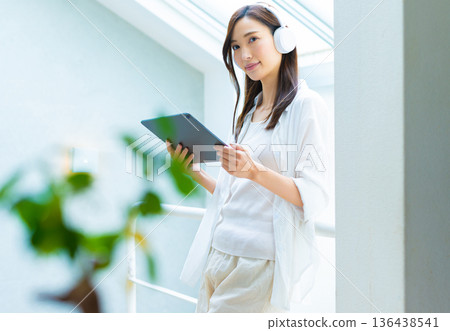 Smiling woman with tablet and headphones 136438541