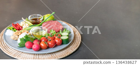 The uncooked ingredients prepared for making yum steak, spicy Thai salad style, are arranged and placed on a local tray set. The uncooked ingredients prepared for making yum steak, spicy Thai salad style, are arranged and placed on a local tray set. 136438627