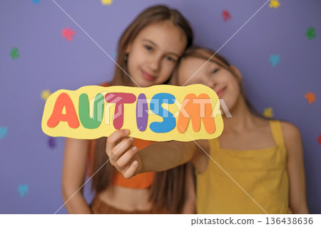 Cute, friendly, kind girls are hugging each other, showing the inscription autism on a postcard made of colorful paper letters. Autism Awareness Day Cute, friendly, kind girls are hugging each other, showing the inscription autism on a postcard made of colorful paper letters. Autism Awareness Day 136438636