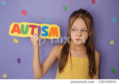 Public coverage and a call for support for people with autism spectrum disorder. The girl shows the inscription with the word autism. 136438642
