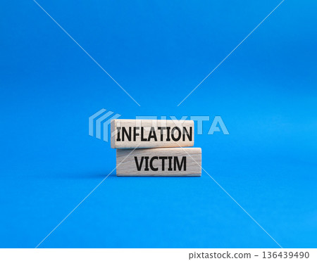 Inflation Victim symbol. Wooden blocks with words Inflation Victim. Beautiful blue background. Business and Inflation Victim concept. Copy space. 136439490