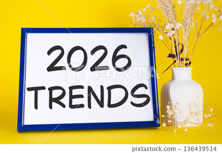 2026 Trends symbol. Concept words 2026 Trends on beautiful wooden picture frame. Beautiful yellow background with flower vase. Business and 2026 Trends concept. Copy space. 2026 Trends symbol. Concept words 2026 Trends on beautiful wooden picture frame. Beautiful yellow background with flower vase. Business and 2026 Trends concept. Copy space. 136439514