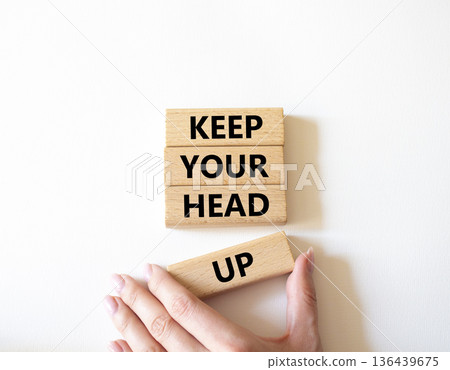 Keep Your Head Up symbol. Concept words Keep Your Head Up on wooden blocks. Beautiful bright white background. Businessman hand. Business and Keep Your Head Up concept. Copy space. 136439675