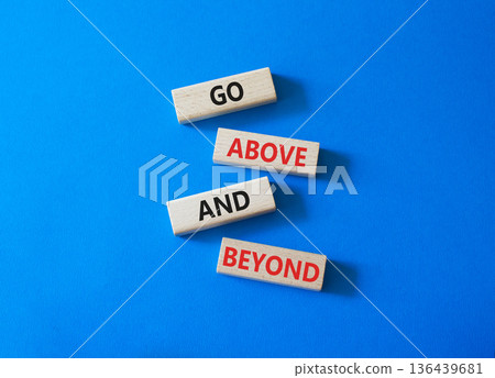 Go above and beyond symbol. Concept words Go above and beyond on wooden blocks. Beautiful bright blue background. Business and Go above and beyond concept. Copy space. 136439681
