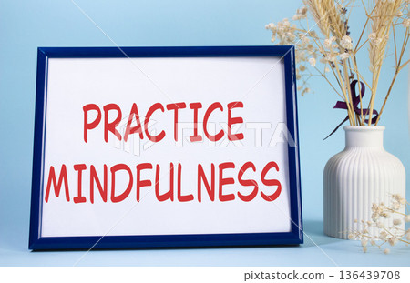 Mindfulness symbol. Concept words Practice Mindfulness on beautiful wooden picture frame. Beautiful light blue background with flower vase. Medical and Psychology concept. Copy space. Mindfulness symbol. Concept words Practice Mindfulness on beautiful wooden picture frame. Beautiful light blue background with flower vase. Medical and Psychology concept. Copy space. 136439708