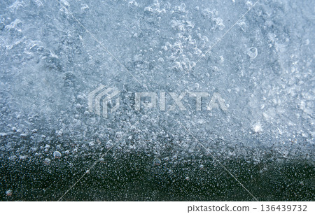 Frozen water with many air bubbles in a close up view. Winter cold concept. Element for nature background 136439732