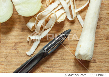 The vegetable peeler lies next to the peeled parsley The vegetable peeler lies next to the peeled parsley 136439865