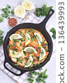 Delicious haddock fish piccata with lemon and capers in cast iron pan, vertical, top view 136439993