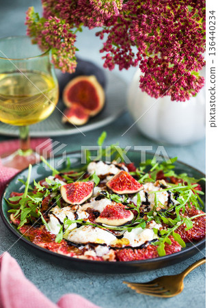 Delicious fresh fig carpaccio with burrata or stracciatella or mozzarella cheese and arugula salad 136440234