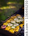 Grilled vegetables (zucchini and bell pepper) on barbecue, green grass background, summer outdoor 136440250