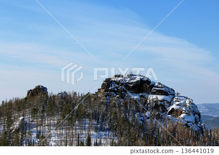 Winter landscape of Krasnoyarsk Pillars national park with snow-capped rock formations and forest for tourism and nature travel. Winter landscape of Krasnoyarsk Pillars national park with snow-capped rock formations and forest for tourism and nature travel. 136441019