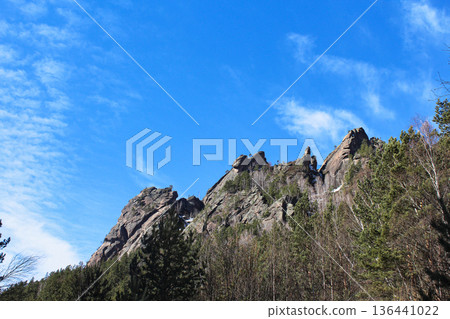 Natural rock formation called Stolby and forest under bright blue sky. Krasnoyarsk Stolby national park in winter. Siberian nature landscape. Takmak rock 136441022